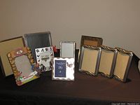 Metal and ceramic picture frames displayed on surface, showing various sizes and styles.