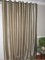Six taupe-colored drapery panels hung on rod showing fabric texture and color.