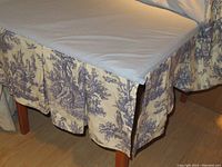 Bed skirt with pleats in navy and white toile de Jouy cotton fabric covering bed base
