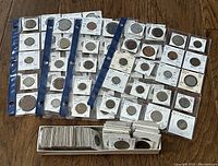 Overview of multiple sheets of 2x2 coin cardboard flips laid out with a tray of additional flips