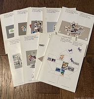 Nine softcover stamp booklets arranged partially overlapping on wooden floor