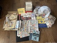 Overall view of albums, stock pages, envelopes, box and bags of stamps spread on floor