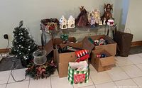 Wide shot of Christmas decorations including trees, boxes, wreaths, and figurines arranged on a wire shelf and floor.