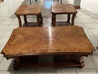Full view of the set including one rectangular coffee table and two square end tables, showing wood grain tops and design.