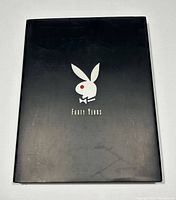 Front cover of the Playboy book with black dust jacket, silver bunny logo with red eye, 'Forty Years' text.
