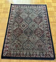 Full view of the rectangular Persian carpet laid on wooden floor, showing overall pattern and condition