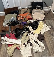 Photo showing collection of ladies gloves, belts, and assorted purses arranged on floor