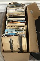 Box containing over 500 postcards stacked upright
