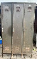 Front view of the three connected vintage metal lockers showing doors, hardware, vents, and condition.