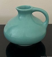 Turquoise Zenith Gouda pottery jug, side view showing rounded shape with narrow spout and handle.