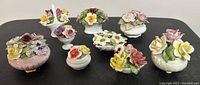Nine vintage fine bone china flower bouquets arranged on a black surface showing variety in shapes and colors