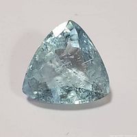 Top view of the aquamarine gemstone showing the triangular trillion cut and visible inclusions.