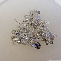 Close up of multiple small loose stones, showing variety of cuts and sizes, clear and reflective