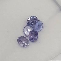 Four oval faceted tanzanite gemstones on white background