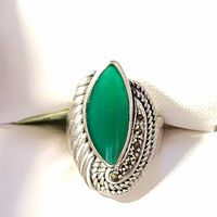Close-up photo showing the silver ring with a marquise-shaped green onyx stone set in the center surrounded by marcasite stones and intricate silver rope and wave designs.