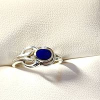 Front view of sterling silver ring with oval blue sapphire stone and loop design