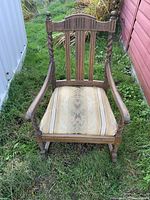 Front view of oak twist spindle rocking chair showing upholstered seat and spindle backrest