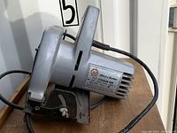 Side view of a Black & Decker circular saw with metal body, ventilation slots, and label on the motor housing.