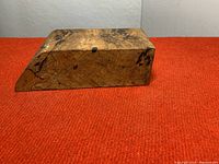 Closed view of the wood burl hidden box showing its angled shape and wood grain pattern.