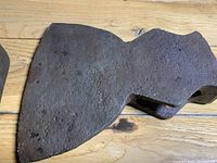 Close-up of one broadaxe head showing rusted surface and blade edge