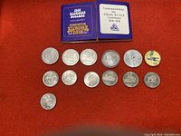 Photo of the full collection of tokens and chips arranged on a flat surface including blue case packaging.