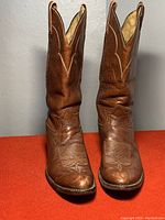 Front view of the pair of brown Tony Lama cowboy boots showing overall wear and decorative stitching
