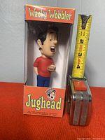 Front view of Jughead Wacky Wobbler bobblehead in original box with measuring tape showing approx 4 inches tall