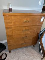 Front and side views showing wood grain, drawer handles, and overall condition of the dresser.