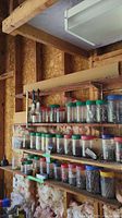 Shelves in garage with plastic jars containing nails, screws, nuts, bolts, and other small hardware items.