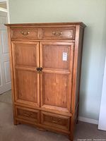 Front view of the solid wood highboy showing upper drawers, double doors, and lower drawers with brass and dark knobs.