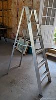 Full view of the 6-foot aluminum A-frame ladder standing open on concrete floor.