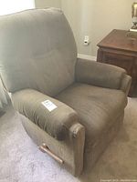 Front angle view of brown Lazy Boy recliner chair with wooden recliner handle on the side, showing armrest and padded cushions.