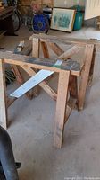 Side view of one wooden saw horse showing construction and condition