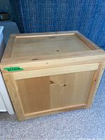 Front view of pine toy box showing hinged lid and panel sides.