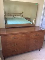 Full view of dresser with mirror on top, showing six drawers and wood grain veneer