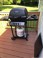 Front and side view of black Huntington Cast propane gas barbecue grill with propane tank below and control panel with three knobs.