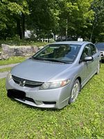 Front three-quarter view of silver Honda Civic showing front bumper, grille and passenger side.