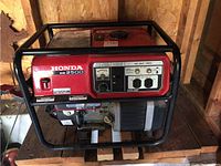 Full front view of red Honda EM2500 generator in black frame