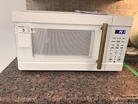 Front view of white Vida by Paderno microwave oven on granite counter showing digital LED display with timer running and control panel with presets