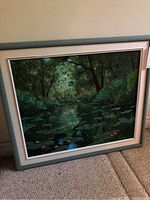 Framed original oil painting showing the full artwork of a small bridge over lily pads with lush green surroundings and pink flowers in a pond.