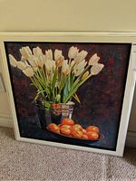 Full view of the framed oil painting showing white tulips in a bucket with oranges on the side.