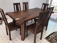 Front angle view of rectangular dining table with six side chairs on tiled floor