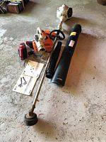 overview showing string trimmer, leaf blower, hand vacuum, charger and manuals