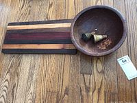Photo showing the coolibah burl wood bowl, multi-wood charcuterie board, and two decorative wooden bottle stoppers (fox and moose inlays).