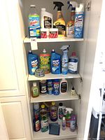 Multiple shelves filled with assorted partially used cleaning products including liquids, sprays, wipes, and jars.