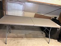 Full view of the folding table set up, showing top surface and legs.