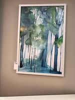 Full view of the framed abstract watercolour artwork with a white frame, showing the green and blue tones in the painting.
