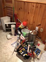 Wide view showing most of the lot with cleaning items, rusty wall panel background, tiled floor