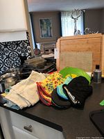 Overview of lot on kitchen counter showing linens, oven mitts, bakeware, and Lagostina pot.