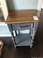 Full view of side table showing top, drawer, legs and shelf